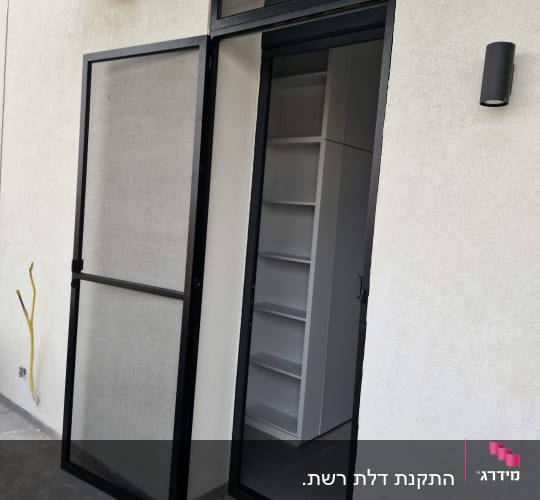 דלת אלומיניום עם רשת ליד קיר חיצוני